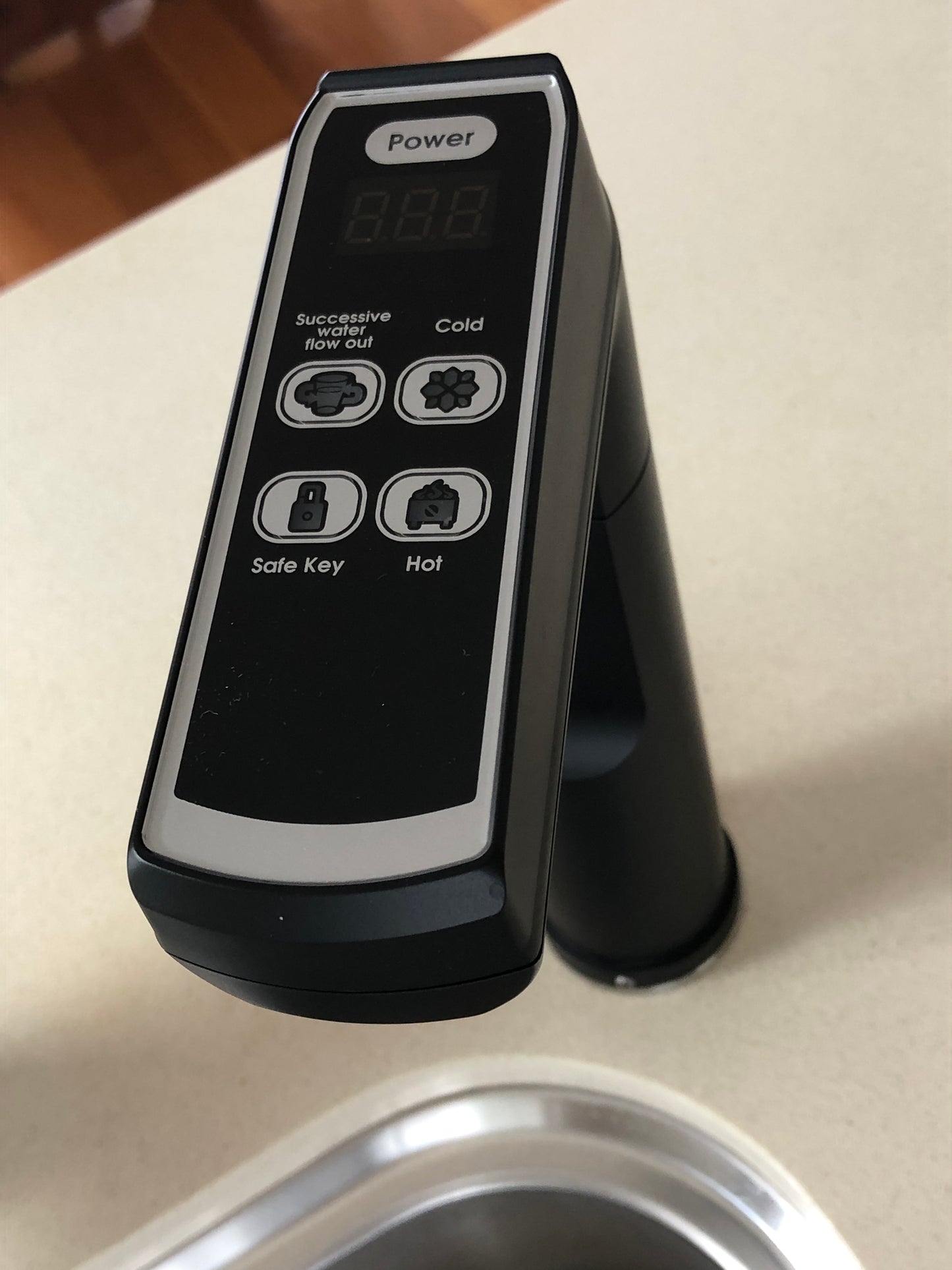 A matte blackl Everboil & Everchill BC Instant Filtered Water tap with a touchpad control panel installed on a kitchen bench top.
